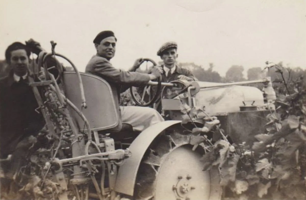 Archive photograph, around 1950: three men with an early tractor working in a field